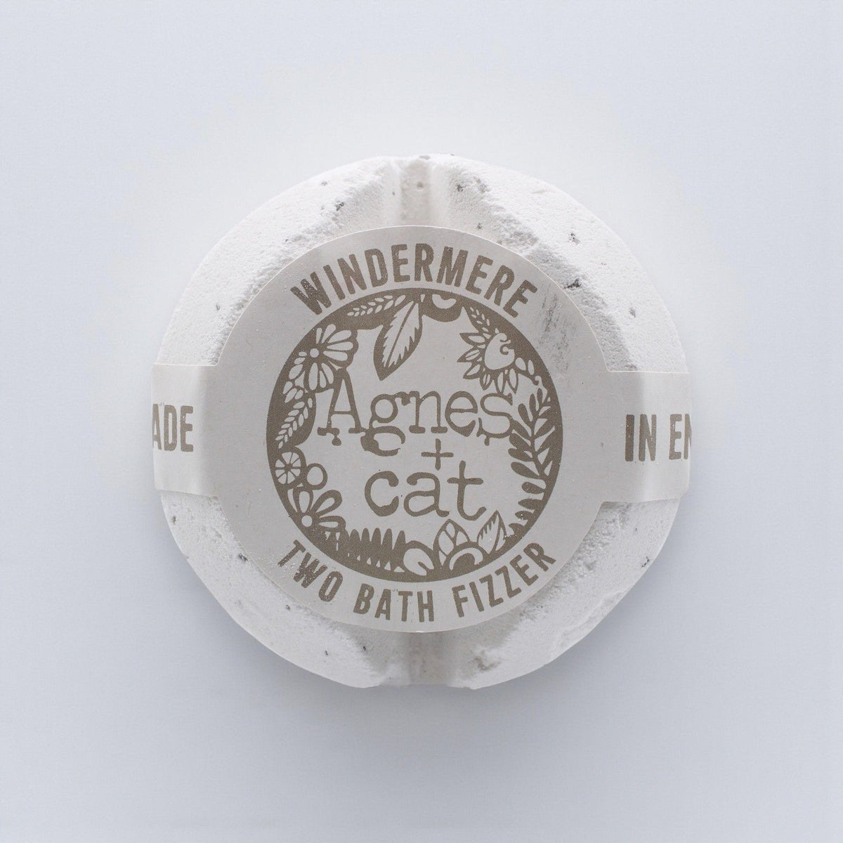 Round bath fizzer with 'Agnes + Cat' branding on a light gray background