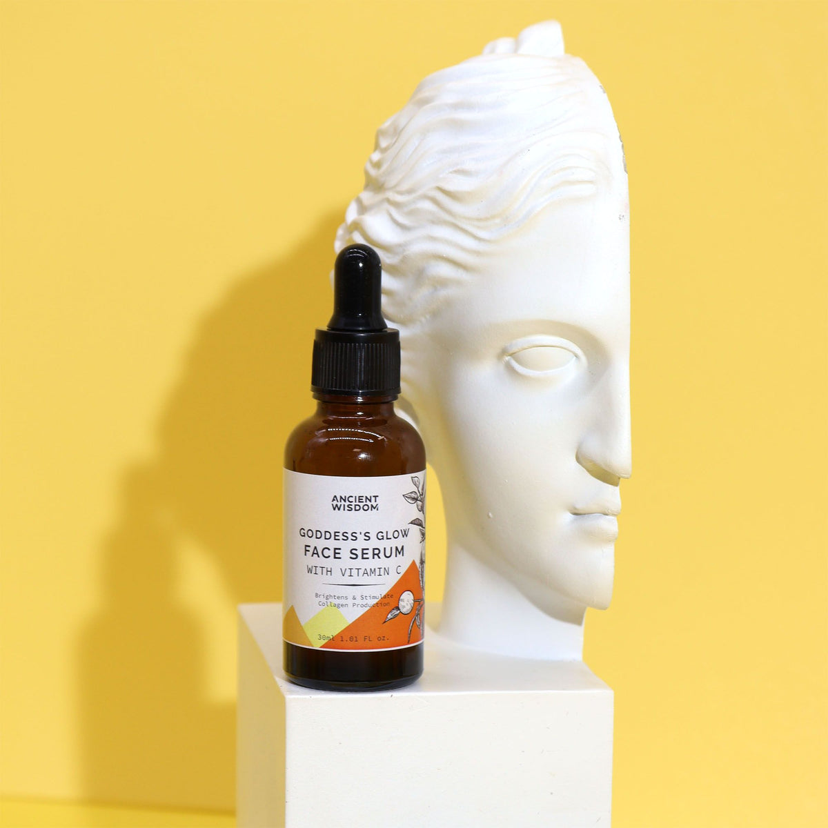 Goddess’s Glow face serum displayed beside white goddess statue
