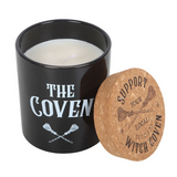 Black candle jar with 'The Coven' text and cork lid featuring a broomstick design on a white background
