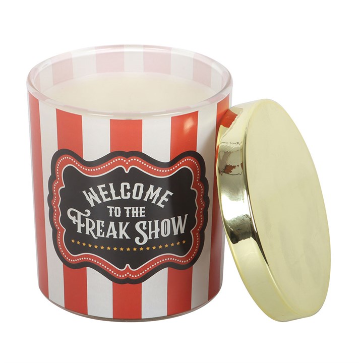 striped candle jar with gold lid and "welcome to the freak show" label