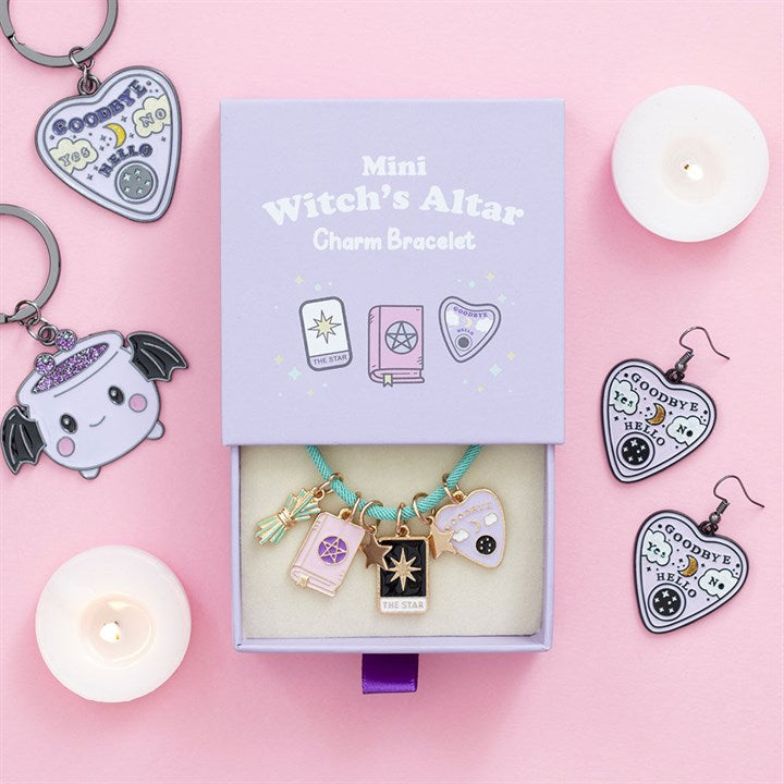 Mini witch's altar charm bracelet set with packaging on a pink background