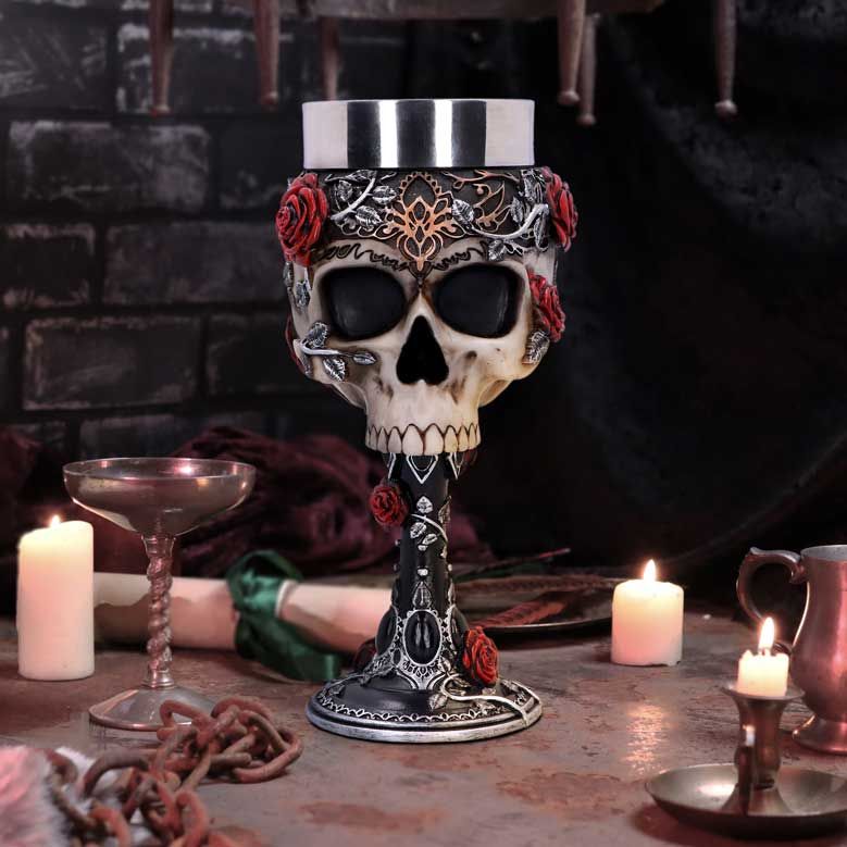 Gothic skull goblet with red roses displayed beside candles