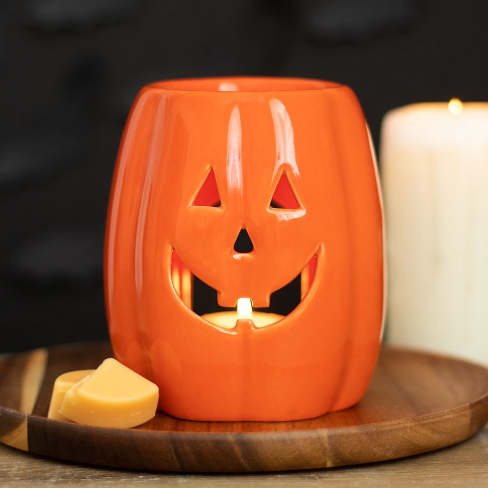 Jack-o'-lantern pumpkin oil burner glowing with tealight