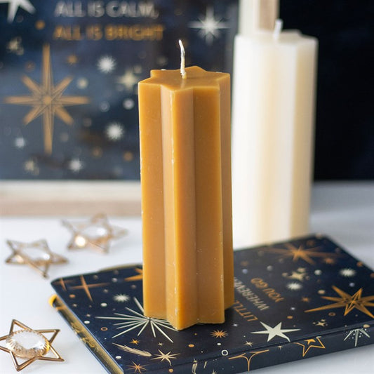 Gold star-shaped candle in celestial Christmas display