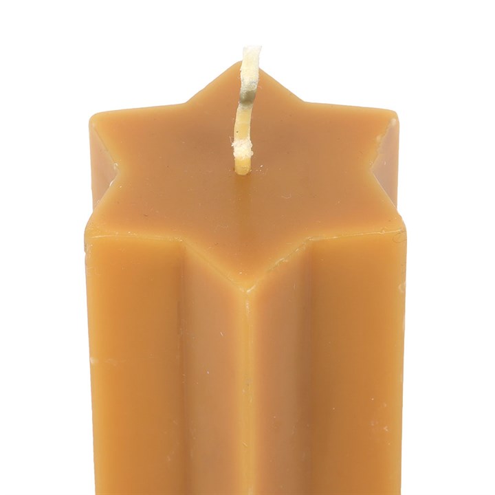 Close-up of wick on gold star-shaped candle