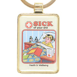 Keychain with cartoon design of a child in bed and text 'Sick of your shit' on a white background