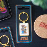 Keychain in packaging with 'Steven Rhodes' branding on a dark surface