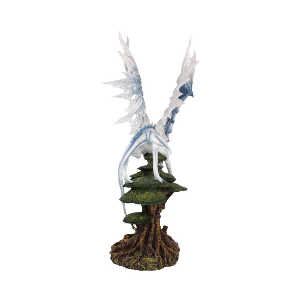 Side view of white icy dragon perched on a tree