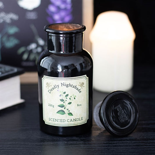 Black bottle of 'Deadly Nightshade' scented candle with a label on a dark surface.