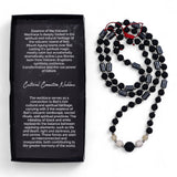 Black beaded necklace next to a black box with text on a white background