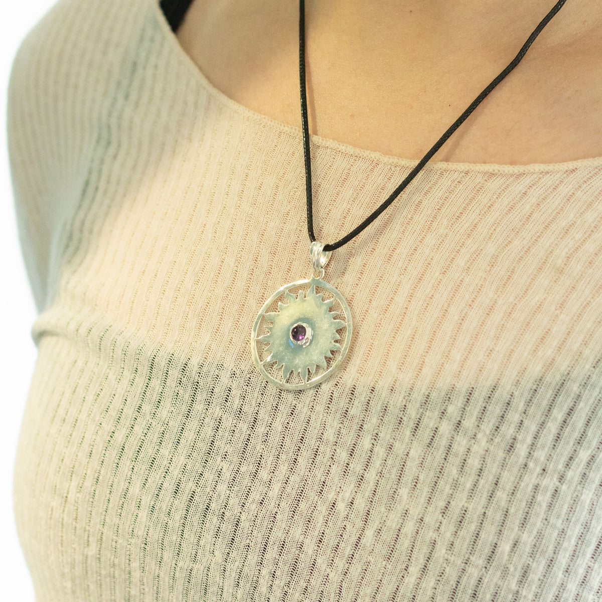 Silver sun pendant necklace being worn
