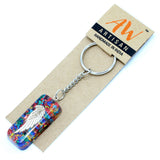Keychain with colorful design and angel wing on a brown card with 'AW Artisan' branding.