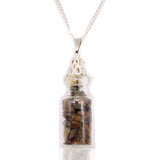 Necklace with a glass bottle pendant containing tiger's eye stones on a white background