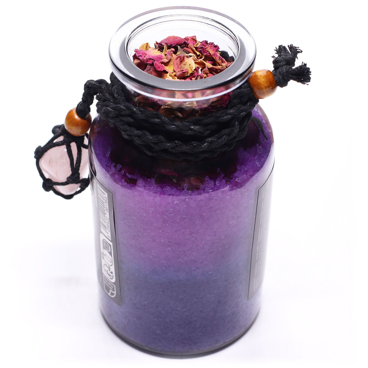 Purple botanical bath potion with rose petals viewed from above