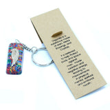 Keychain with angel wing design and information card on a white background