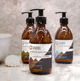Three bottles of Ancient Wisdom hand and body wash on a bathroom counter.