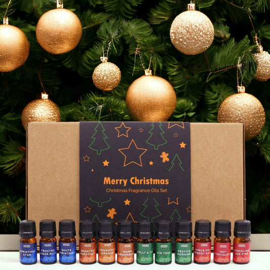 Set of Christmas fragrance oils with decorative boxes and gold ornaments on a green background