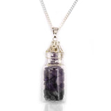 Amethyst crystal in a glass bottle pendant on a white background