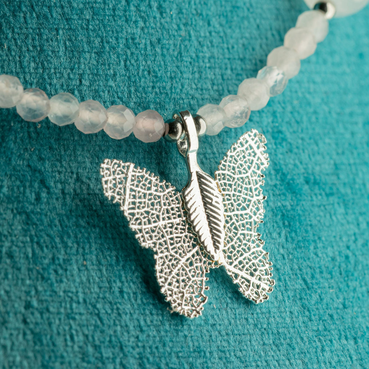 Close-up of silver-plated real leaf butterfly pendant with pink Rose Quartz beads