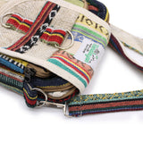 Colorful woven bag with a strap and visible brand label on a white background