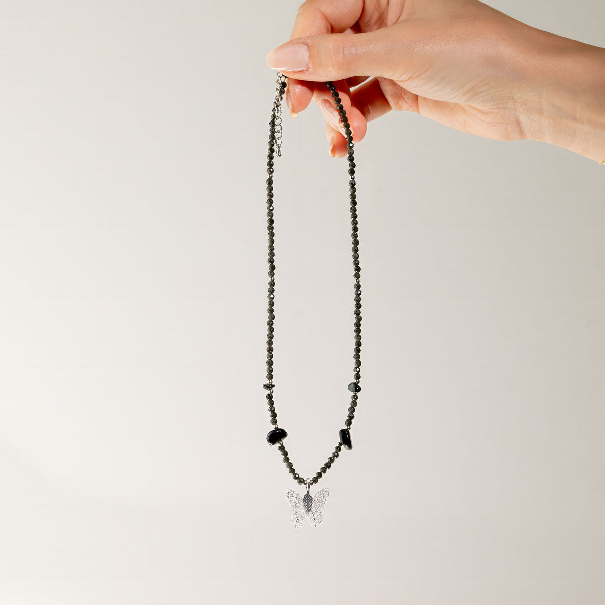 Black Obsidian gemstone necklace held up showing butterfly pendant
