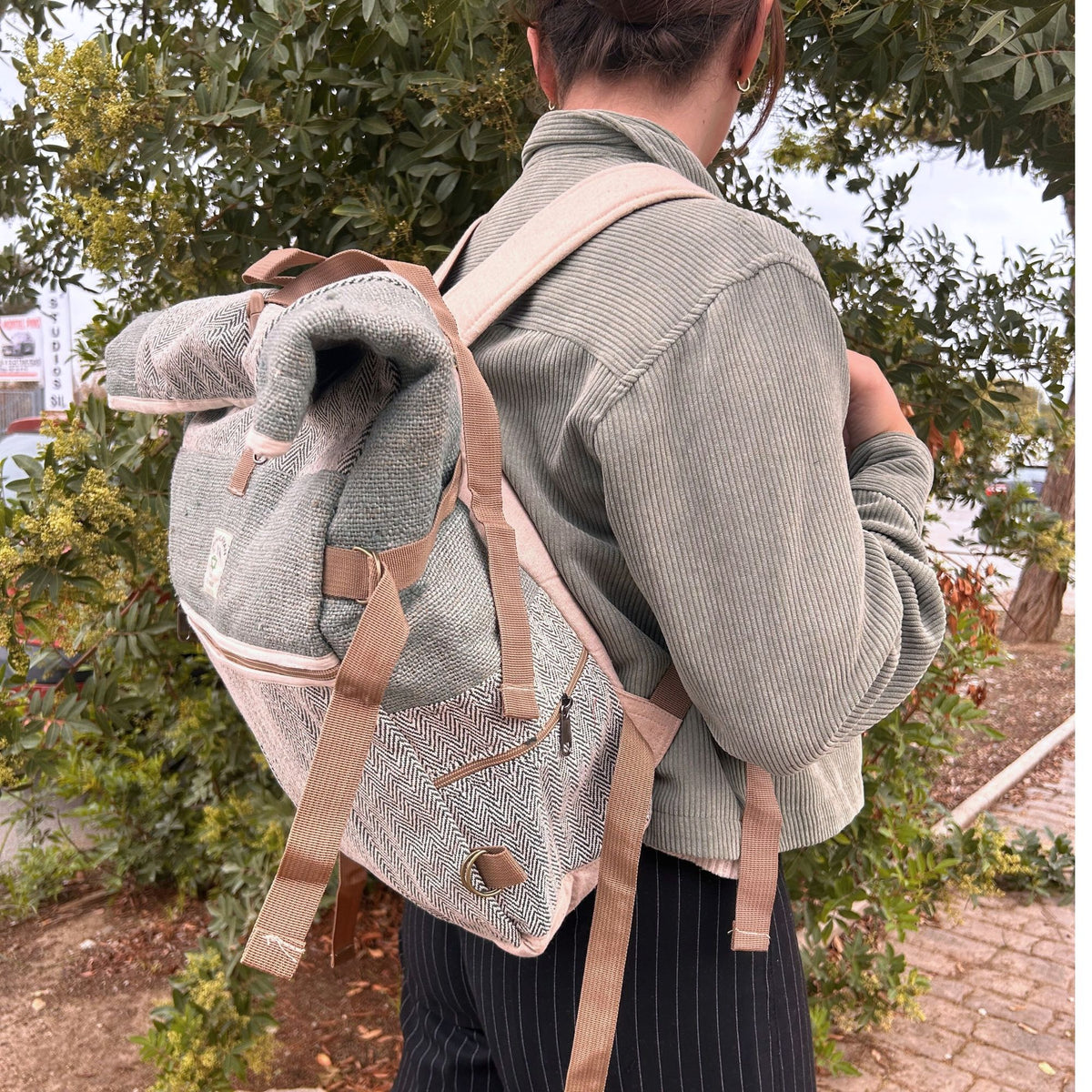 Sage green hemp backpack with rolled top and buckle fastening