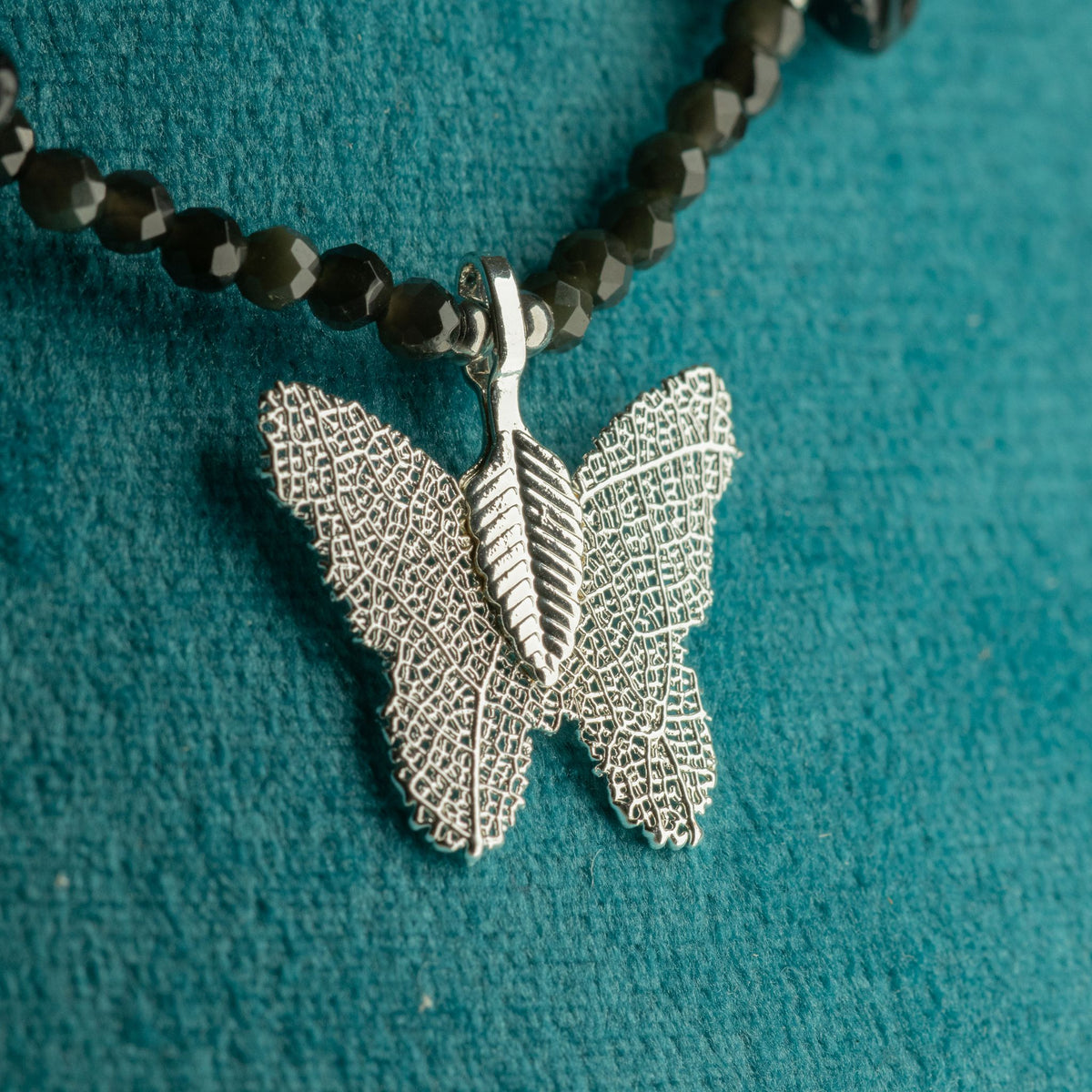 Close-up of silver-plated real leaf butterfly pendant with Black Obsidian beads