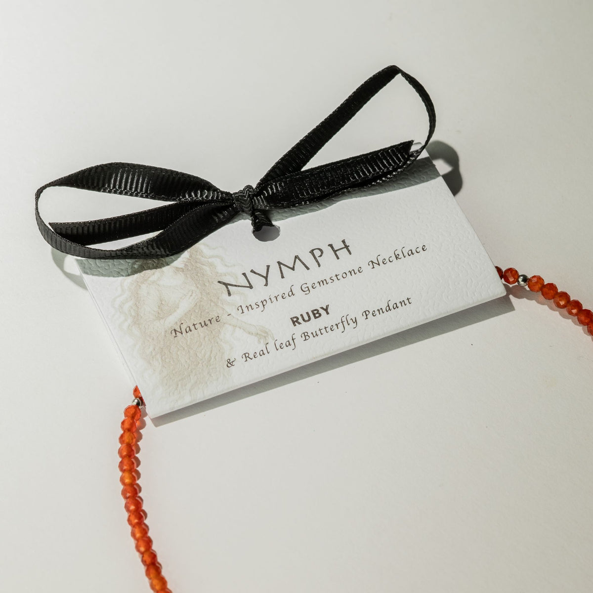 Nymph Ruby necklace with illustrated gift card and black ribbon