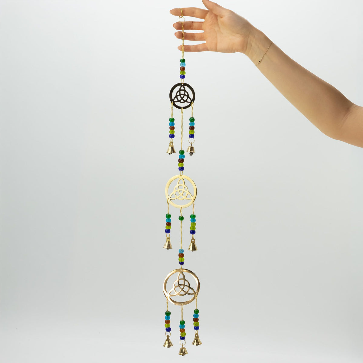 Long Celtic brass wind chimes held up to show the hanging design