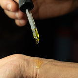 Ancient Witch Eclipse Oud perfume oil being applied with a dropper