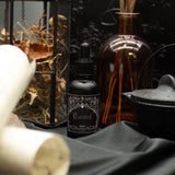 Black bottle labeled 'Cursed' with decorative elements on a dark background