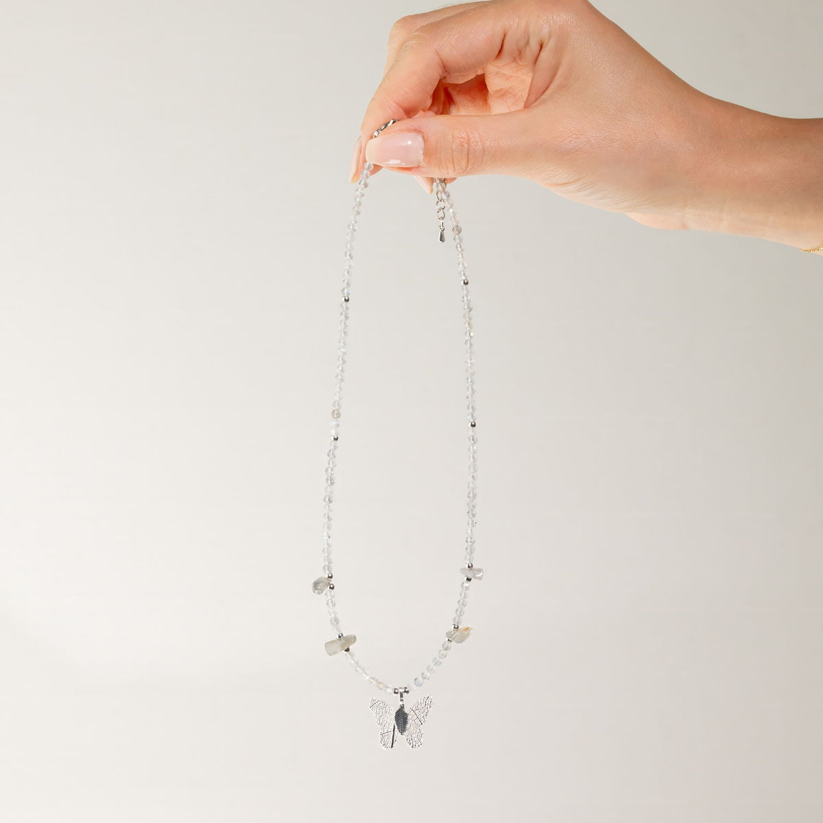 Labradorite gemstone necklace held up showing full length and butterfly pendant