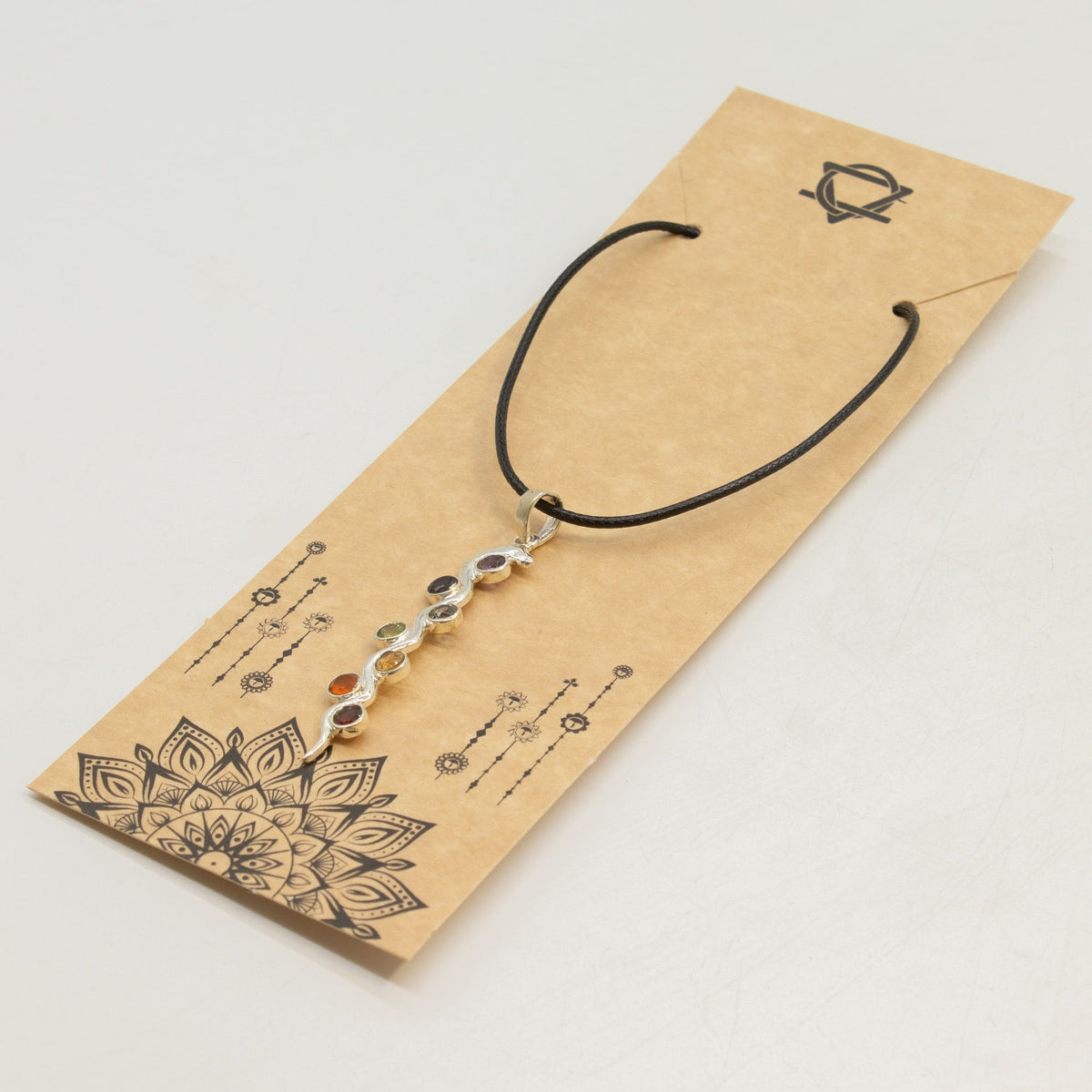 Snake chakra pendant necklace on jewellery display card