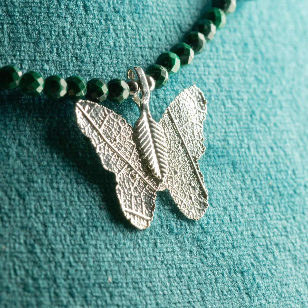 Close-up of silver-plated real leaf butterfly pendant with green Malachite beads