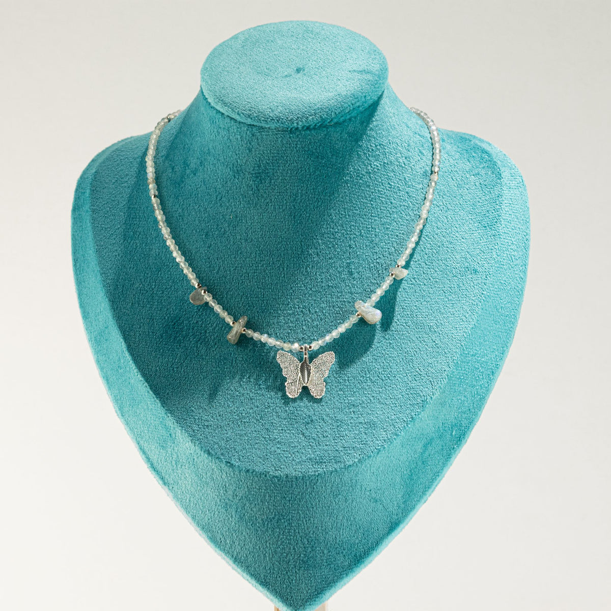 Labradorite butterfly necklace displayed on turquoise jewellery bust
