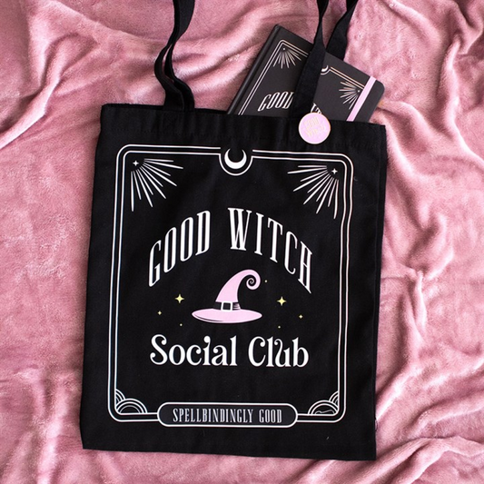 Black Good Witch Social Club tote bag and enamel pin badge on pink fabric