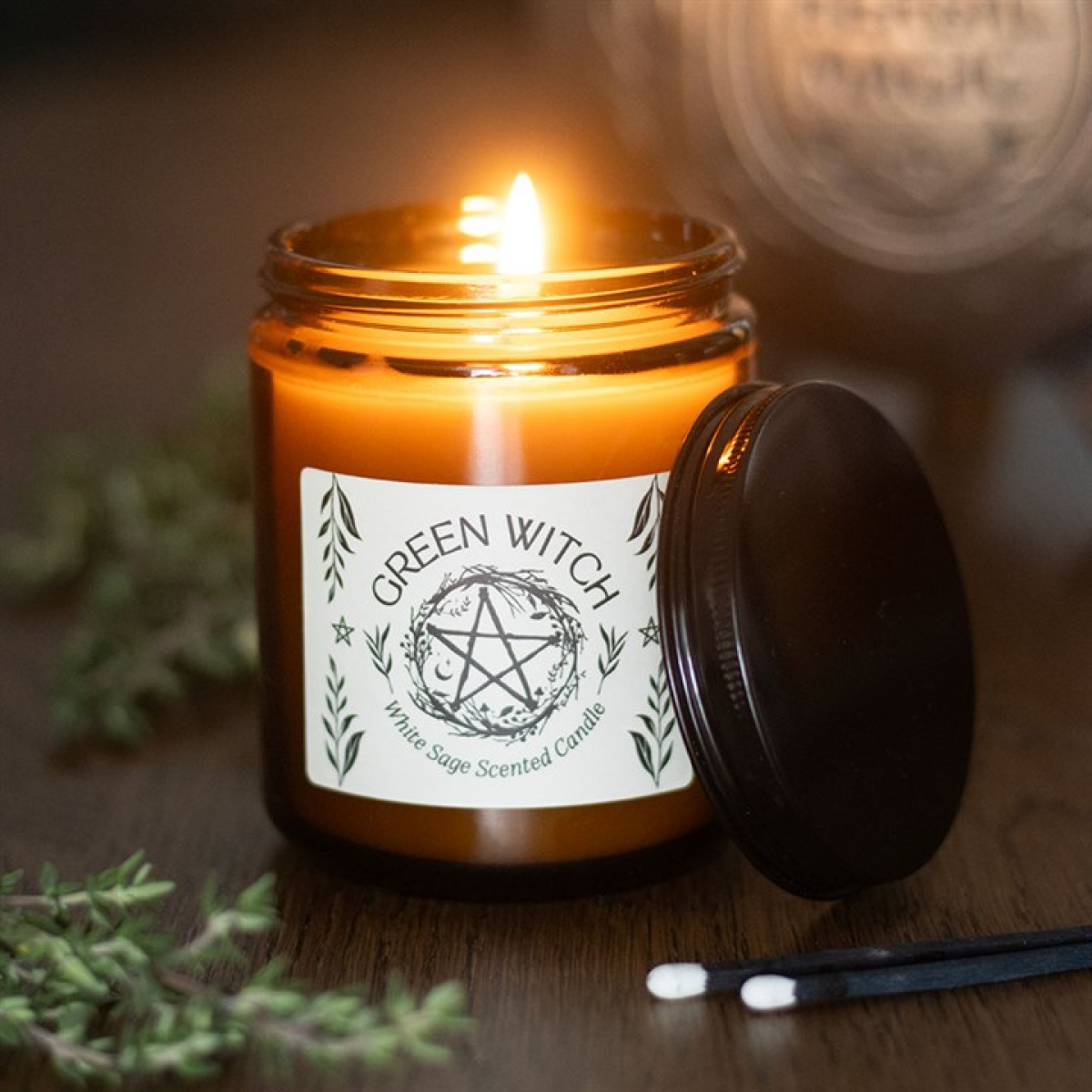 Green Witch white sage candle burning in amber glass jar