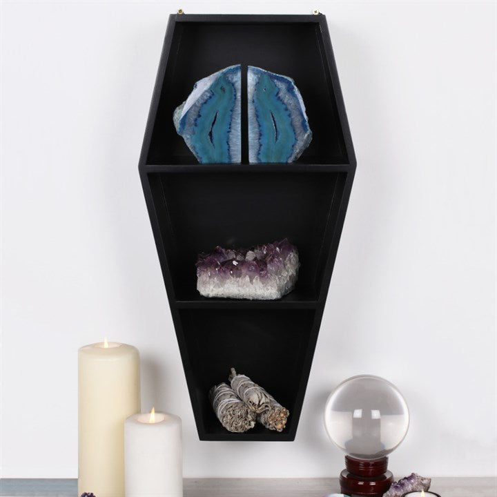 Black coffin wall shelves displaying crystals and gothic ornaments