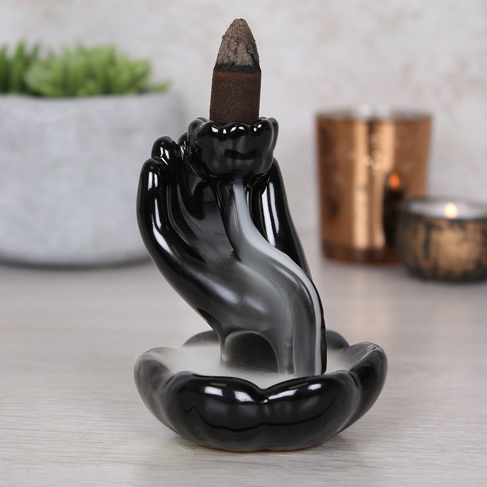 Black hand and lotus backflow incense burner with smoke